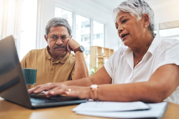 Older couple reviewing laptop together at home