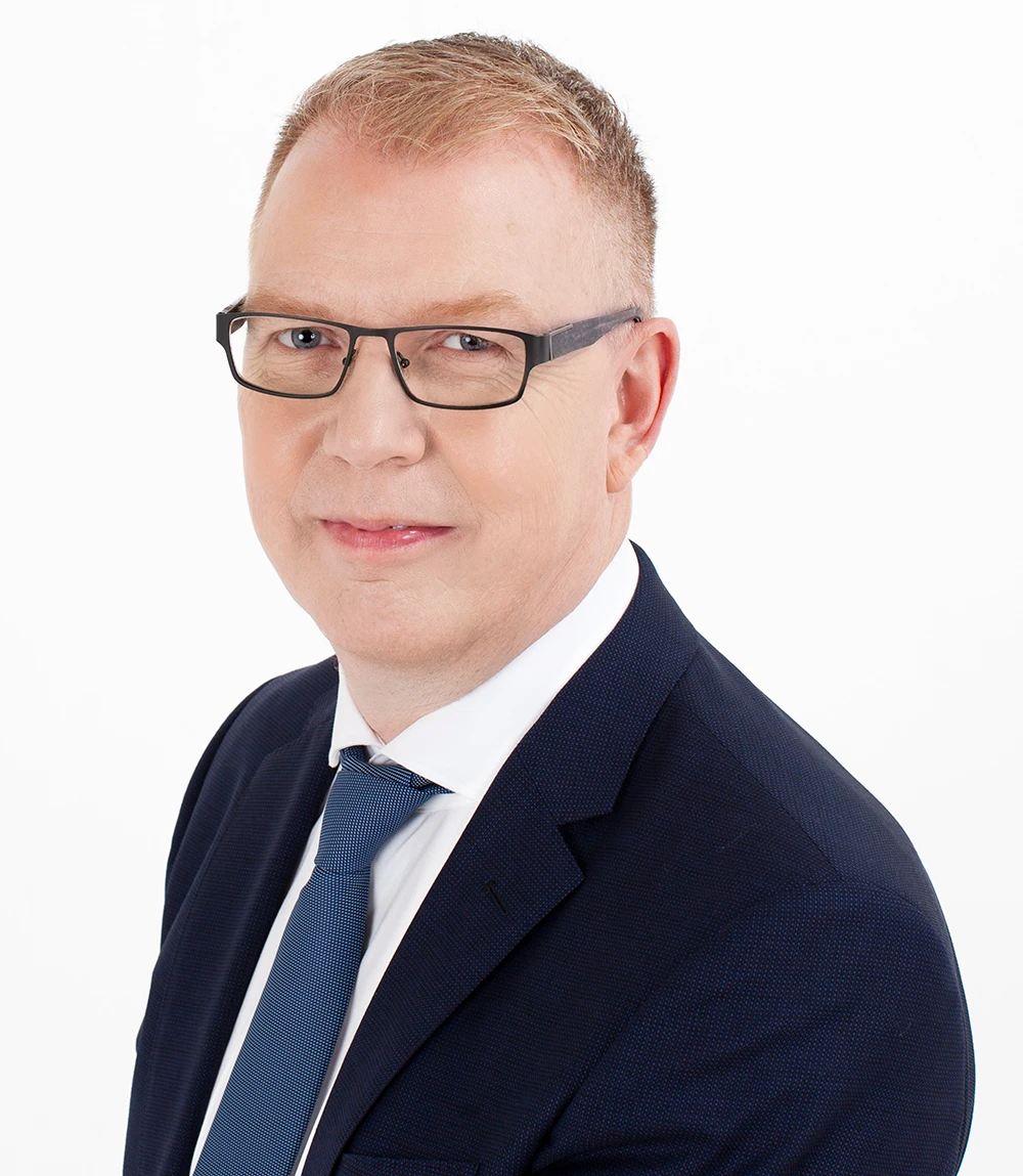 Professional headshot of man in suit and glasses